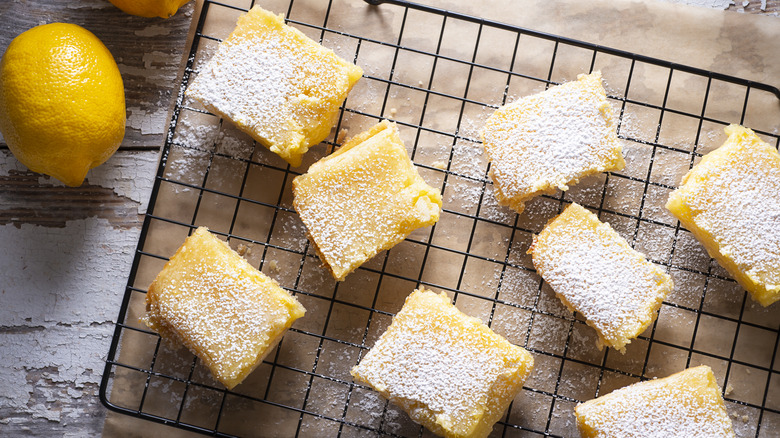 lemon bars on black rack with lemons