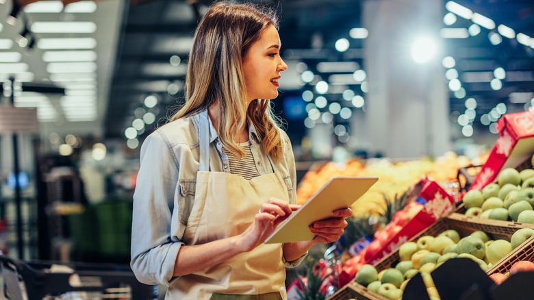 Grocery store employee taking inventory