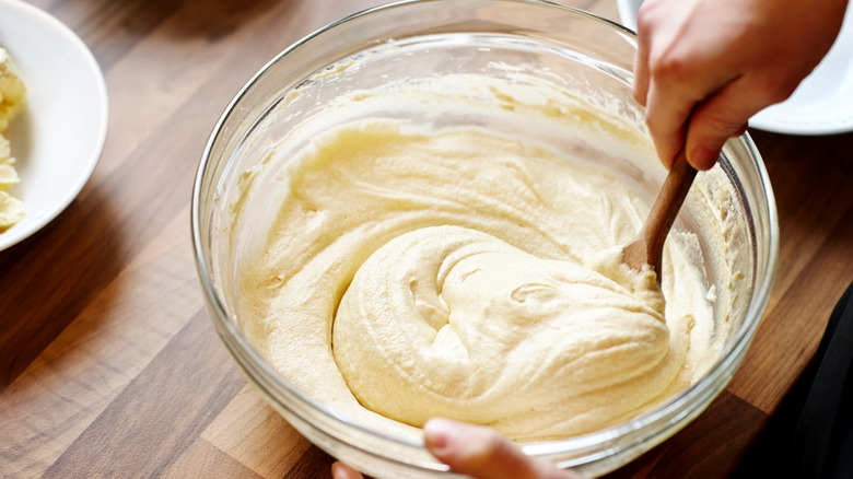 Mixing together cake batter with wooden spoon