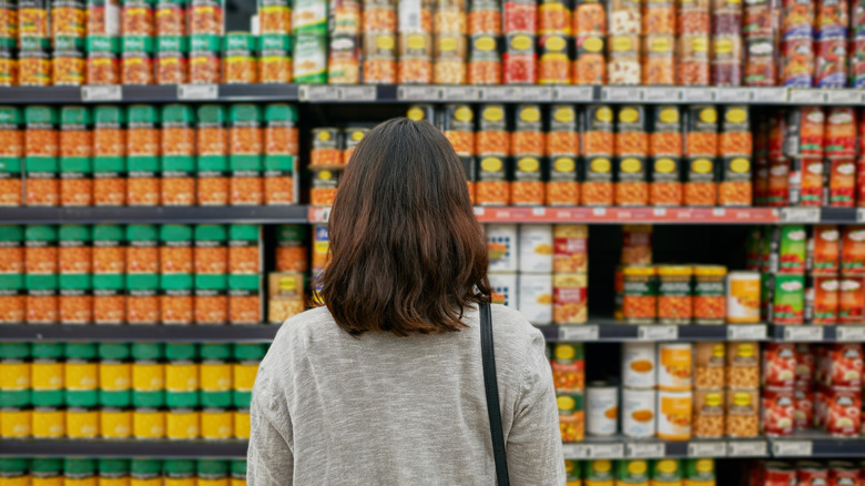 Woman in front of canned food display