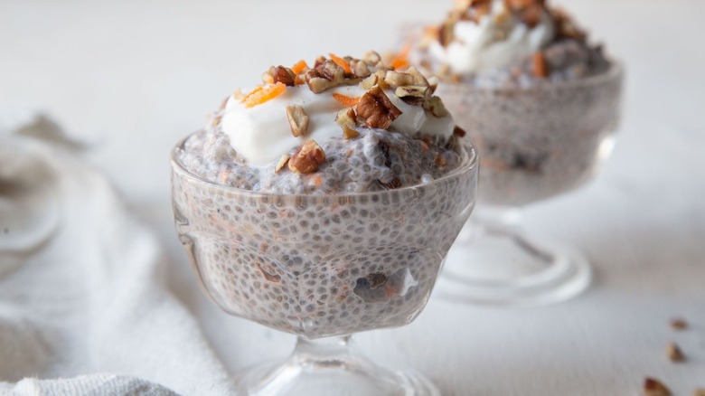 Chia pudding in glass bowls with yogurt, pecan, and carrot toppings
