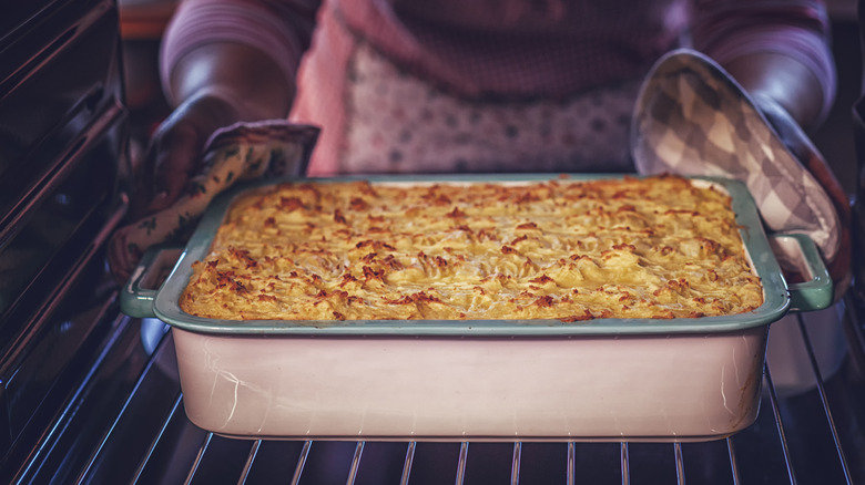 pulling casserole from oven