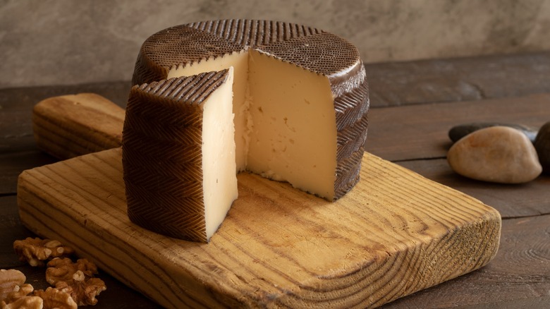 cheese wheel sliced on board