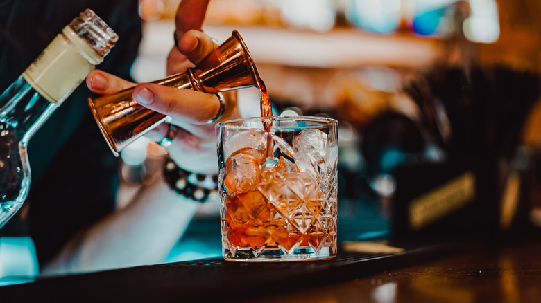 Bartender pouring a Malört liqueur Negroni cocktail