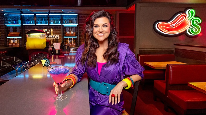 Tiffani Thiessen posing in '90s-themed attire at a Chili's bar with the Radical 'Rita