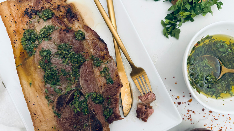 pork steak with chimichurri on white plate