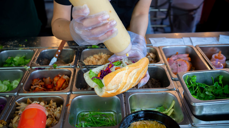 Server prepares a fresh bahn mi sandwich