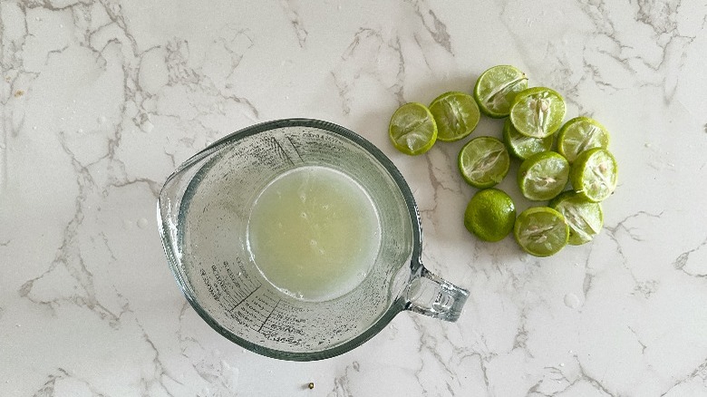 juiced limes next to measuring cup