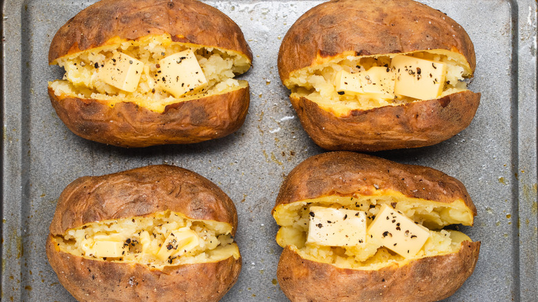 classic baked potatoes on baking sheet