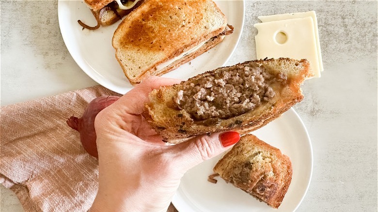 sliced patty melt in hand