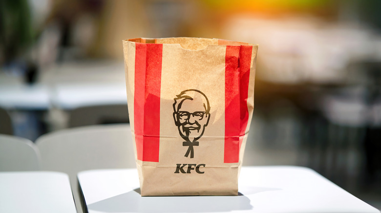 A KFC bag with a stylized black and white drawing of Colonel Sanders
