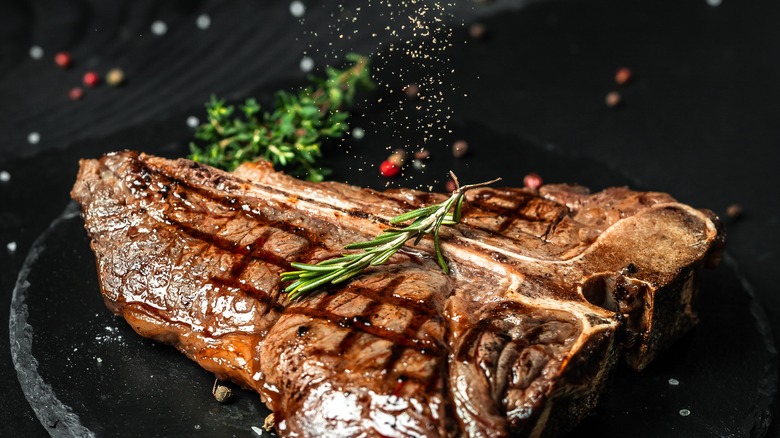 Sprinkling seasoning on steak