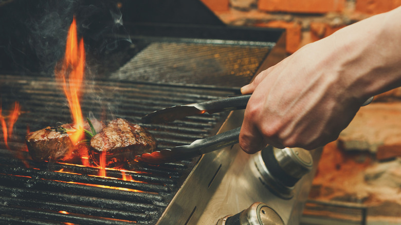 Flipping a steak on a grill