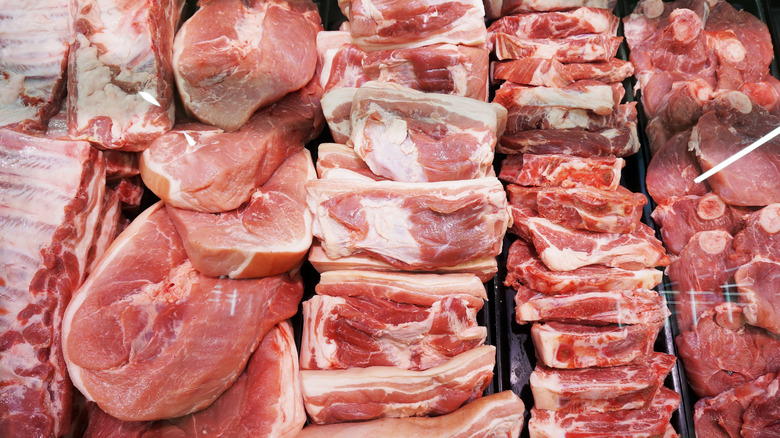 Many different cuts of meat arranged together against a black background