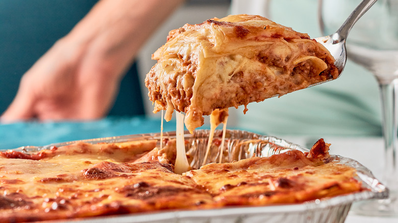 Lasagna being lifted from dish