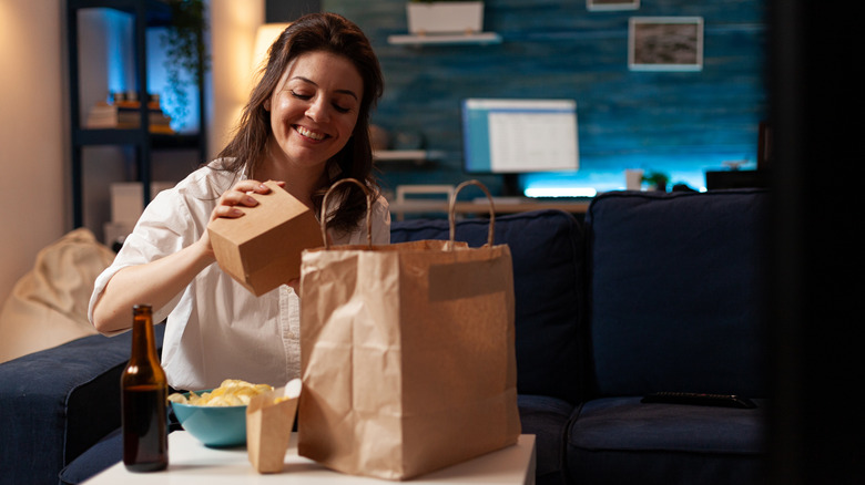 A woman eats dinner in front of the TV