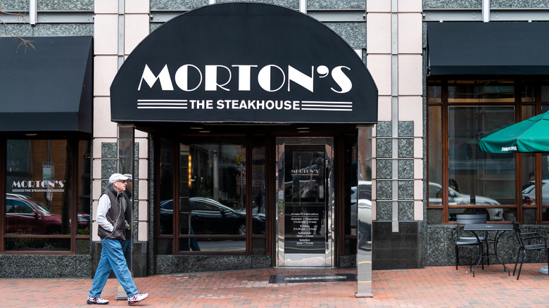 front view of a Morton's in a city with a black awning reading Morton's the Steakhouse