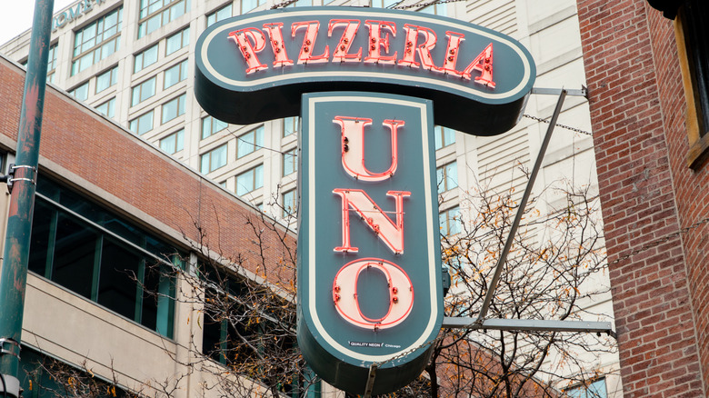 the classic vertical Pizzeria Uno sign with neon red letters in downtown Chicago