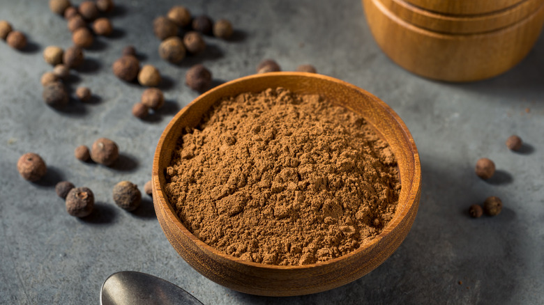 ground allspice in wooden bowl
