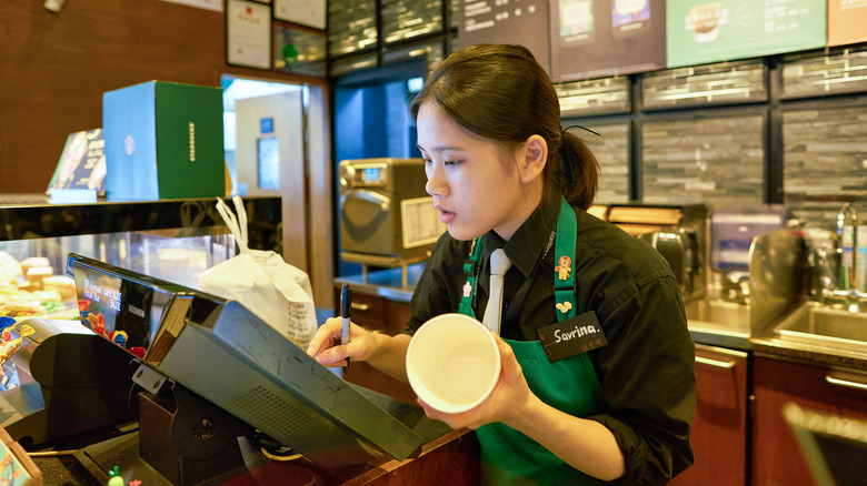 A Starbucks barista at a register