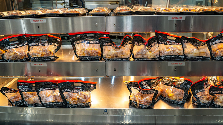 Rotisserie chickens on warming shelves in Costco.