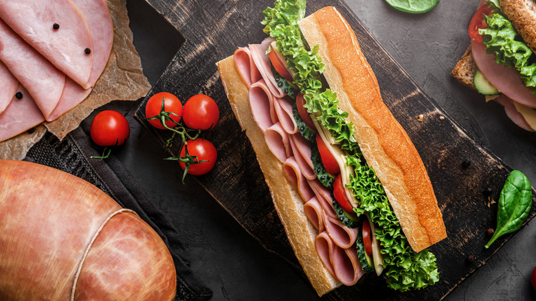ham sandwich surrounded by cuts of ham and a whole deli ham