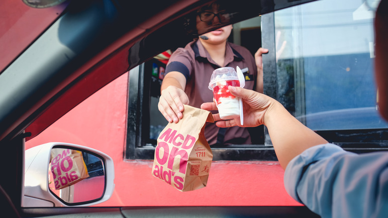 employee handing off mcdonalds bag to customer