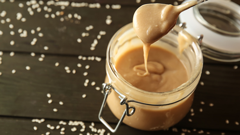 Spoon of tahini with jar