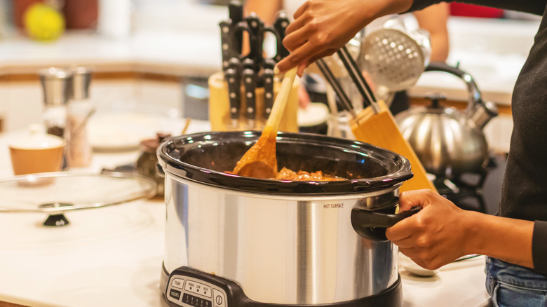 Person using slow cooker