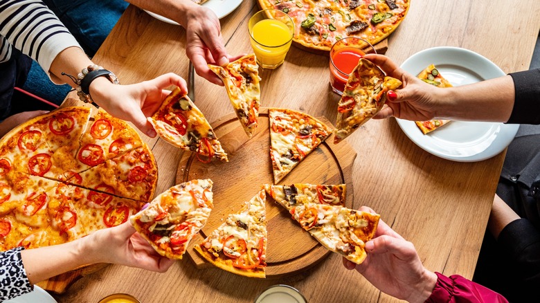 Friends sharing a pizza at a restaurant 