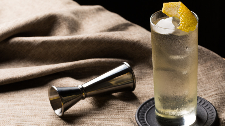 A Japanese Highball cocktail sits next to a cocktail jigger