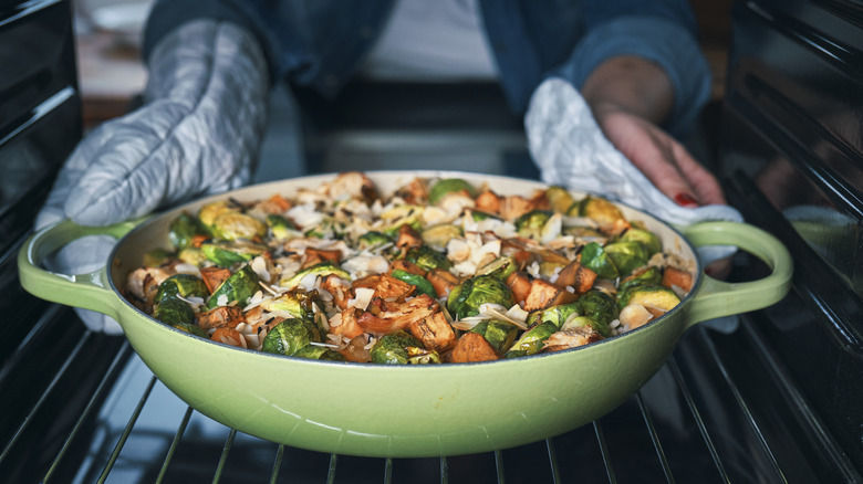 Person putting casserole in oven
