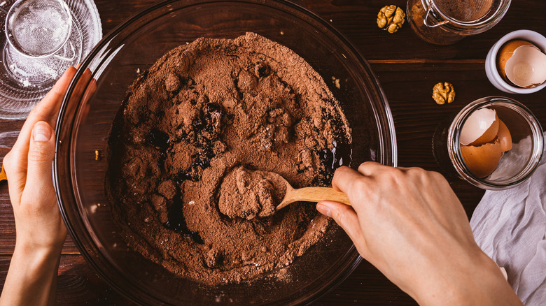 Hands stirring cocoa powder