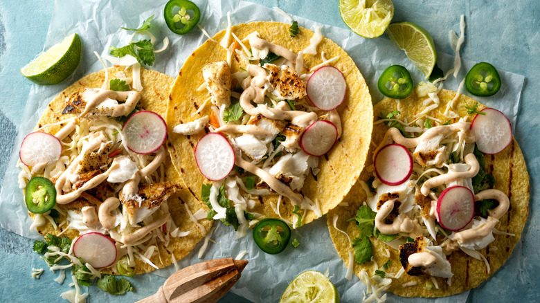 Three fish tacos with sour cream