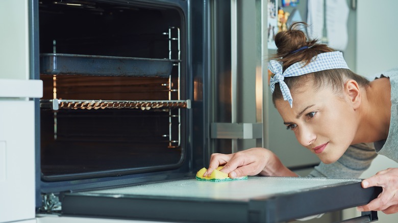 Person cleaning an oven door
