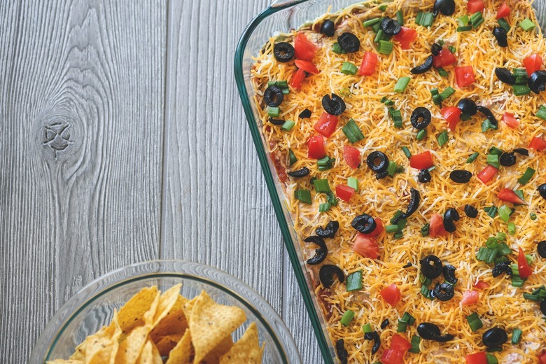 how to make easy 7 layer dip recipe - the daily meal