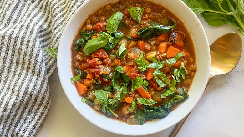 lentil soup in bowl with gold spoon