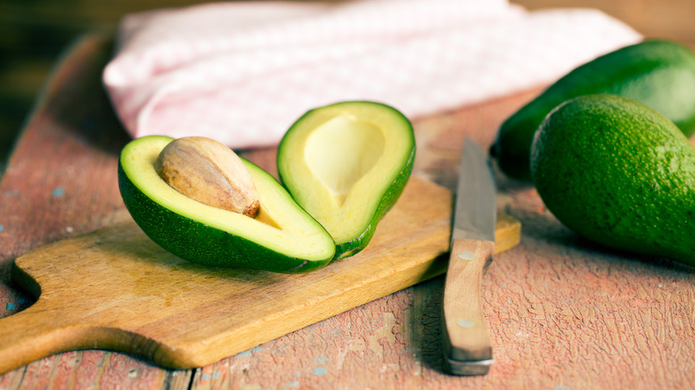 halved avocado on cutting board