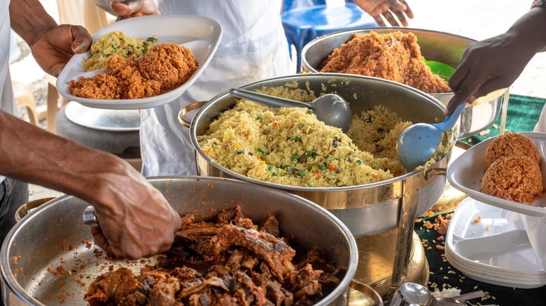 Jollof and fried rice being served at a gathering.