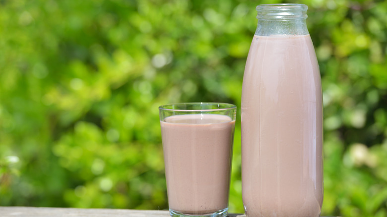Mug of chocolate milk next to glass