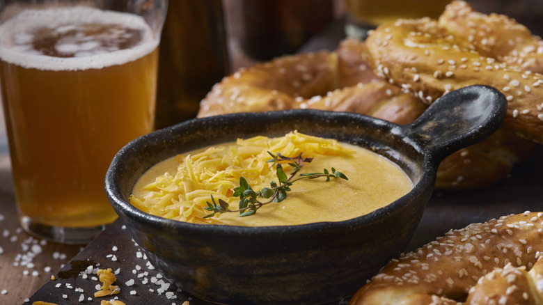 Beer cheese with beer and pretzels in background