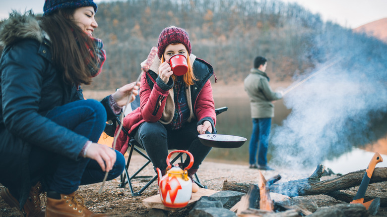 Campers eating around fire