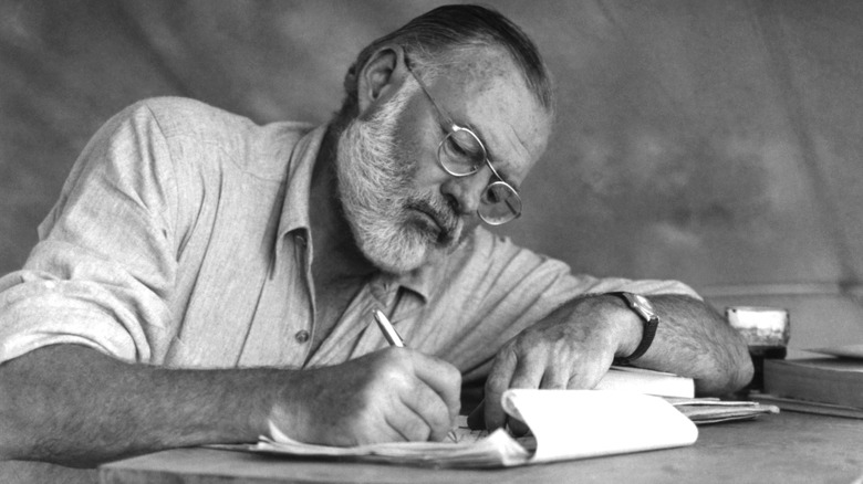 Ernest Hemingway writing with pen and paper