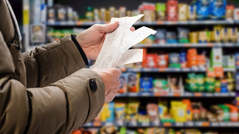 Man viewing grocery store receipts