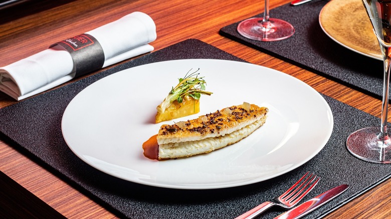 A white plate with dover sole and parsnip