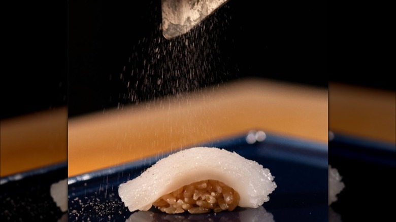 Sprinkling seasoning over sashimi