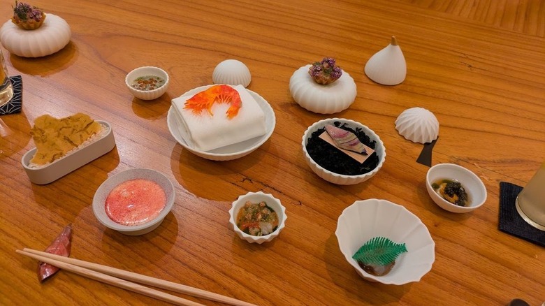 Table with various small bowls of shrimp, dipping sauces, and appetizers
