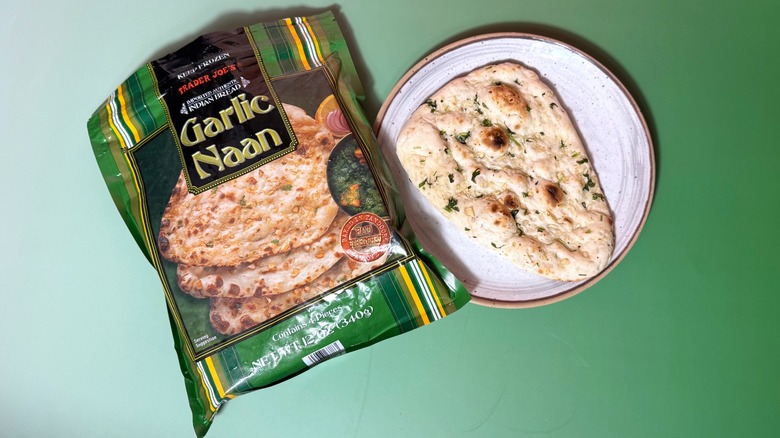 A bag of Trader Joe's garlic naan and one piece of bread on plate