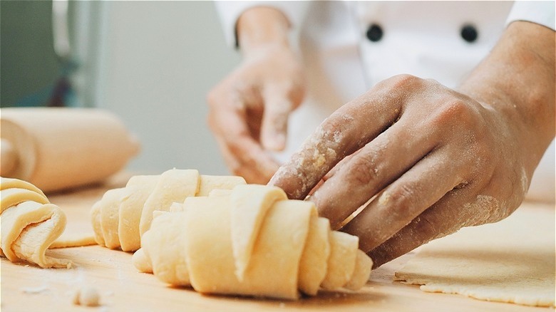 person making croissants