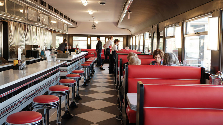 Interior of a restored 1939 dining car with red booths and checkerboard floors